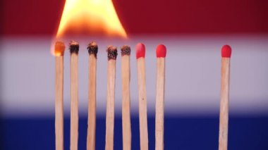 Evde kal, Coronavirüs salgınını önle. Hollanda haritasının arka planında kibrit yakılıyor. Kavram: salgın hastalık, domino etkisi, COVID-19, Wuhan virüsü, izole edilmiş kibritler, Hollanda için dua.