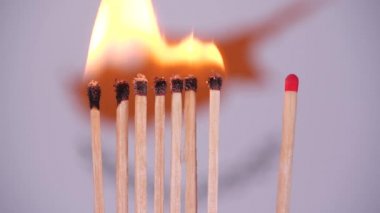 Evde kal, Coronavirüs salgınını önle. Kıbrıs haritasında kibrit yakılıyor. Kavram: yaygın salgın, domino etkisi, COVID-19, Wuhan virüsü, izole edilmiş kibritler, Kıbrıs için dua