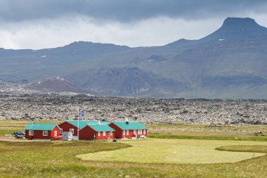 Geleneksel evler ve arka planda bir dağ olan bir dosyada İzlanda bayrağı
