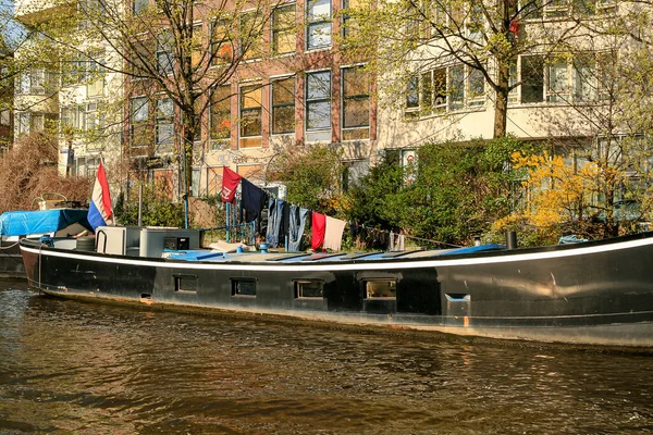 Одежда Висящая Над Старой Черной Лодкой Голландским Флагом Канале Амстердаме — стоковое фото