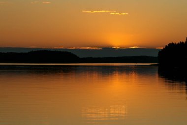 Finlandiya 'da bir gölün üzerinde gün batımı
