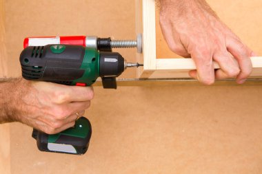 Ahşap arka planda matkap sürücüsü Whit vida. El ve vida tabancası ya da tahta vida tutan matkap. Ahşap mobilya yapmak. 