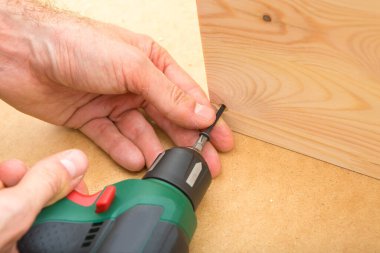 Ahşap arka planda matkap sürücüsü Whit vida. El ve vida tabancası ya da tahta vida tutan matkap. Ahşap mobilya yapmak. 