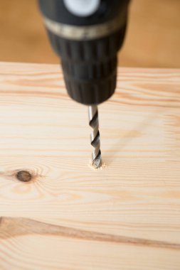 Ahşap arka planda matkap sürücüsü Whit vida. El ve vida tabancası ya da tahta vida tutan matkap. Ahşap mobilya yapmak. 