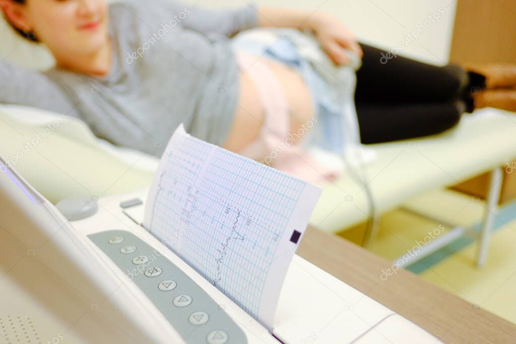 Woman at doctor office whit ctg or ecg.  Ctg pregnancy at hospital. 