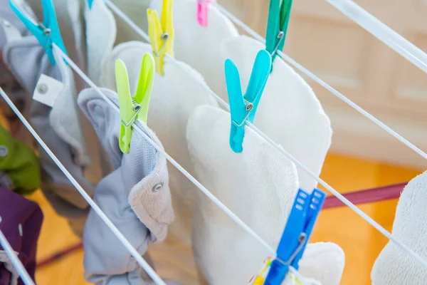 尿布在室内洗衣服 生态尿布在房间里擦干 色彩斑斓的尿布在烘干 可重复使用的尿布和浸渍器 — 图库照片