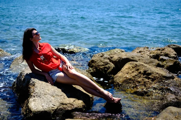 girl woman in red by the sea. Girl on a cost of european sea. Woman on vacation dress in read.
