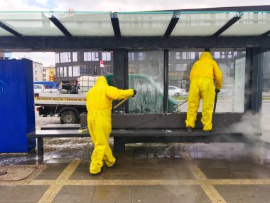 Kielce / Polonya 30.03.2020 Coronavirus 'u önlemek için otobüs durağını temizleyen kişi. Covid-19 dezenfeksiyonu