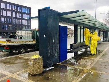 Kielce / Polonya 30.03.2020 Coronavirus 'u önlemek için otobüs durağını temizleyen kişi. Covid-19 dezenfeksiyonu