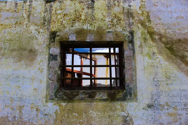 old window with rusty bars on old wall, abandoned wall, background