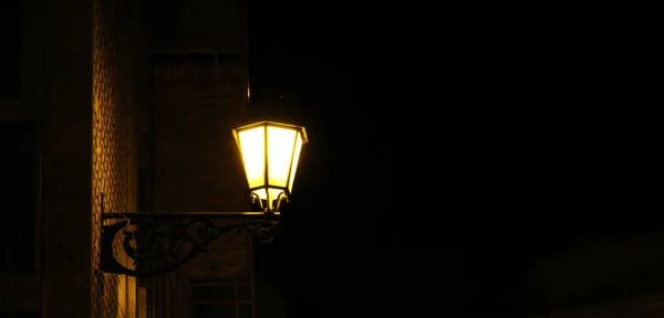 A street lamp at night with the light.