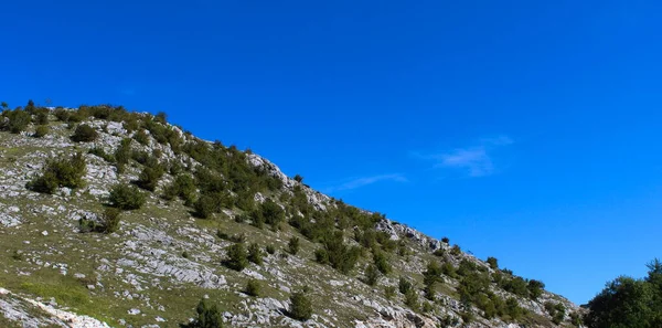 从山上升起的横幅 那里有很多石头 有的地方有草 有的地方到处都是灌木丛 在去Bjelastic Nica山的路上 — 图库照片