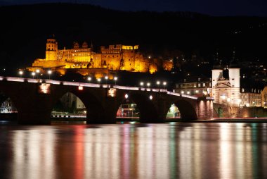 Heilderberg, Almanya, 08 Şubat 2020: Kalenin ve nehir kenarındaki eski köprünün gece görüşü.