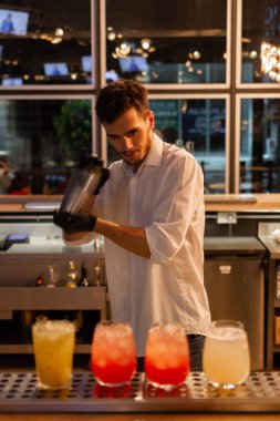 Gece kulübünde çalışan profesyonel genç barmen. Kokteyl konsepti