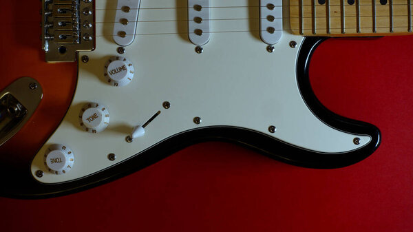 Electric guitar closeup . Red background