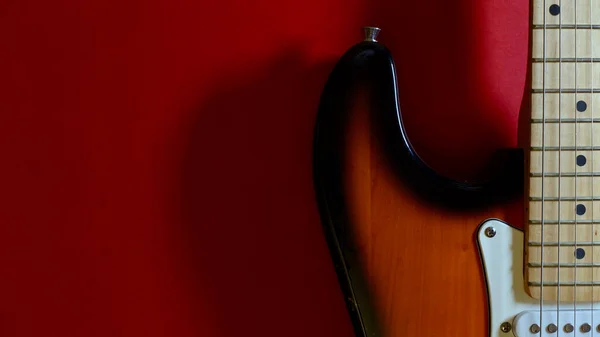 electric guitar closeup . red background