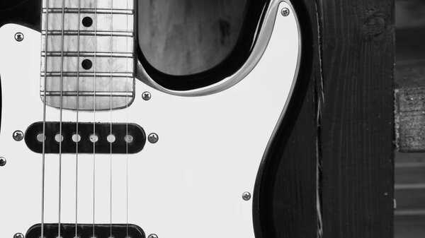 Electric guitar closeup on the wooden boards . Black and white