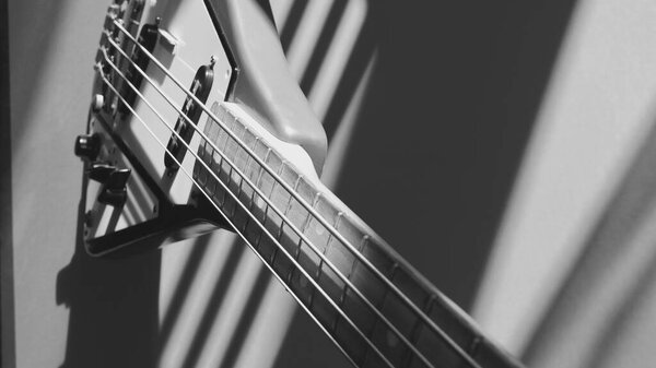 Old vintage bass guitar closeup in the sun light. black and white