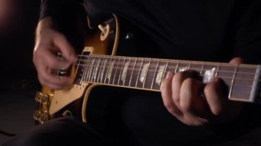 Gitarist, Slow Motion 100 Pp stüdyosunda gitar çalıyor. koyu arkaplan
