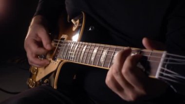 Gitarist stüdyoda gitar çalıyor. koyu arkaplan