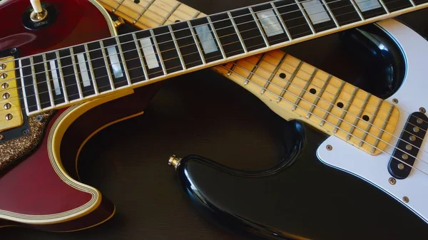 two vintage electro guitars closeup . dark background