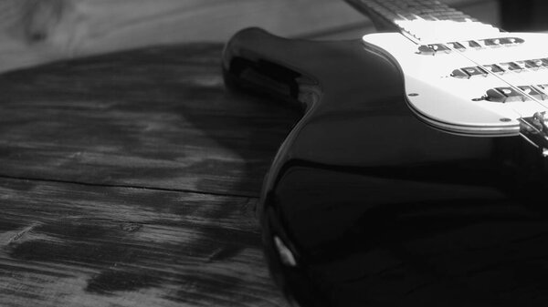 Electric guitar on the wooden boards in the old barn . black and white