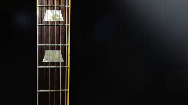 Vintage guitar neck closeup . Dark background . Copy space