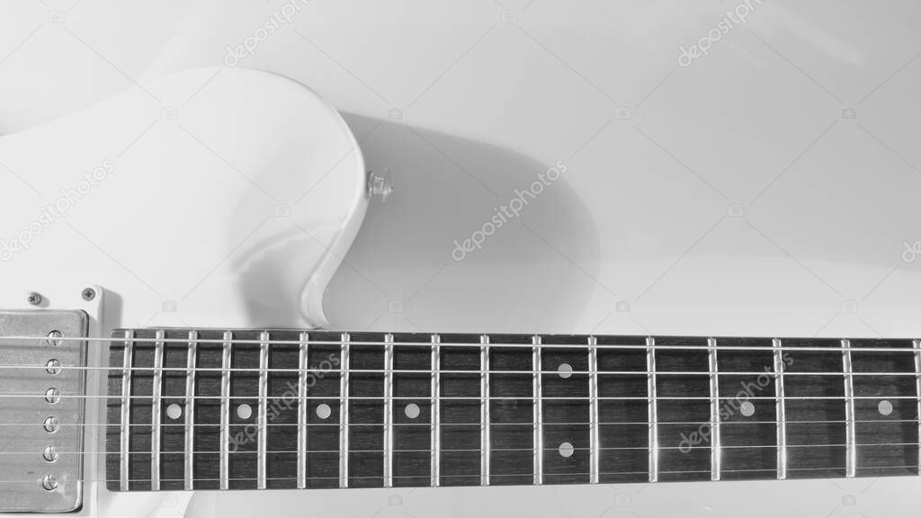 White electric guitar closeup . White background with copy space . black and white