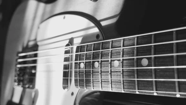 electric guitar and piano keyboards closeup in the sun light . Light and shadows . black and white