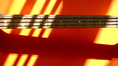 Eski moda bas gitar, güneş ışığında yakın plan. Renkli arka plan. Boşluğu kopyala