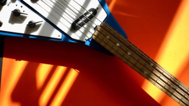 Eski moda bas gitar, güneş ışığında yakın plan. Renkli arka plan. Boşluğu kopyala