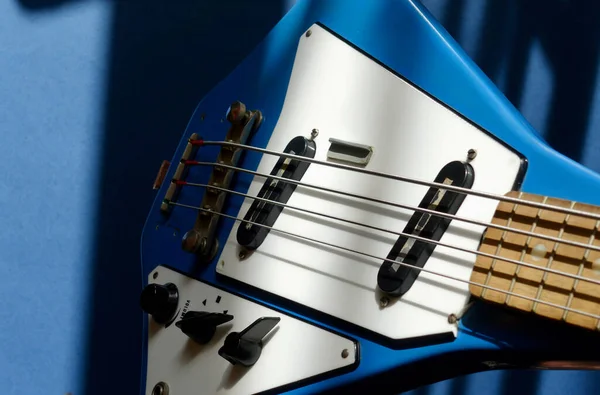 Old vintage blue bass guitar closeup . Color  background . Copy space