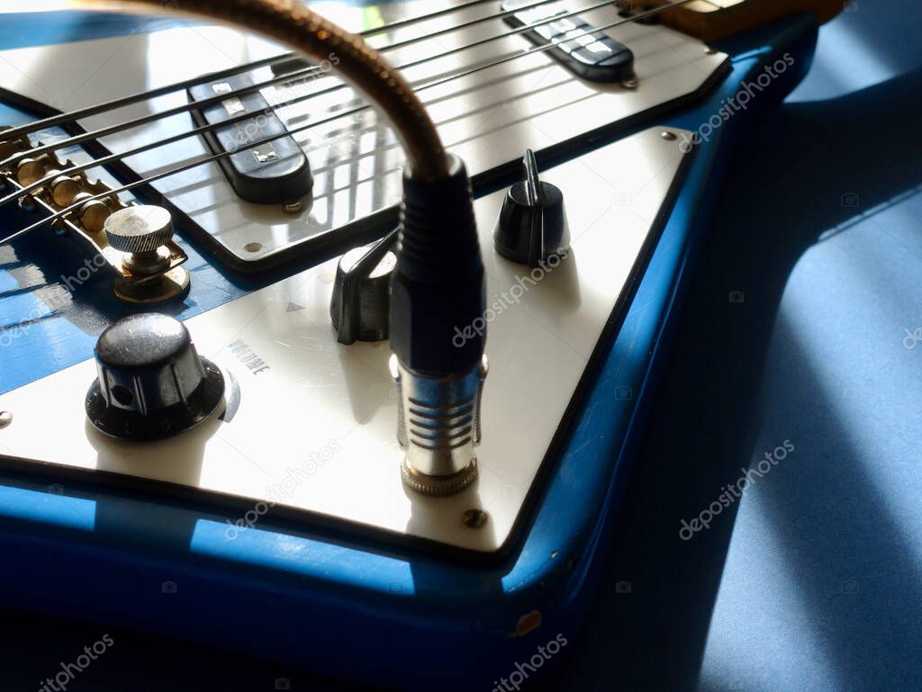 Old vintage blue bass guitar closeup . Color  background . Copy space 