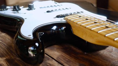 Tahtanın üzerinde elektro gitar kapağı var.                               