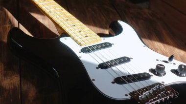 Tahtanın üzerinde elektro gitar kapağı var.                               
