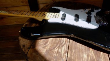 Tahtanın üzerinde elektro gitar kapağı var.                               