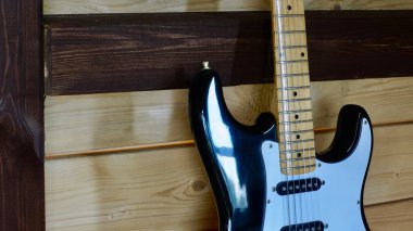 Tahtanın üzerinde elektro gitar kapağı var.                               