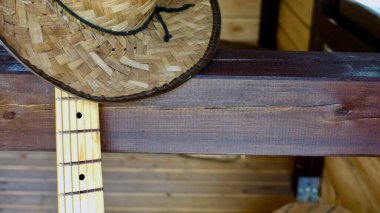 Elektro gitar ve kovboy şapkası ahşap tahtaya yakın plan.                               