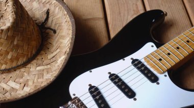Elektro gitar ve kovboy şapkası ahşap tahtaya yakın plan.                               