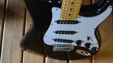 Tahtanın üzerinde elektro gitar kapağı var.                               
