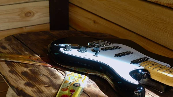 木制木板上的电吉他和回旋棒 — 图库照片