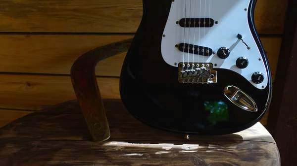 木制木板上的电吉他和回旋棒 — 图库照片