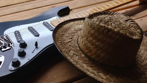 木制木板上的电吉他和牛仔帽 — 图库照片