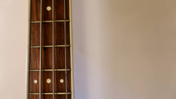 Bass guitar neck closeup . Copy space . White background