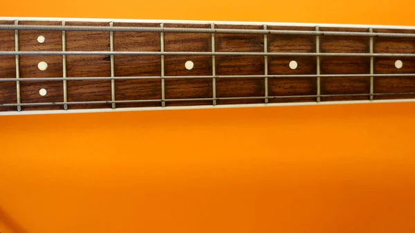 Bassgitarre Hals Nahaufnahme Kopierraum Orange Hintergrund — Stockfoto