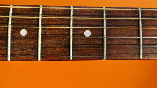 Guitar headstock closeup . Orange background