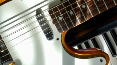 Güneş ışığında elektro gitar ve piyano klavyeleri 