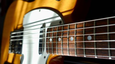 Elektro gitar kapanışı. Karanlık arka plan. Güneş ışığı 