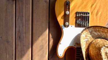 Tahtada klasik elektro gitar ve kovboy şapkası..