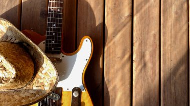 Tahtada klasik elektro gitar ve kovboy şapkası..
